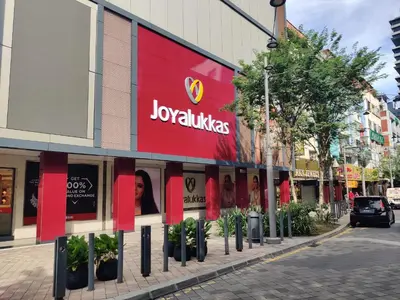 a store with a red sign on the side of a street at Hotel WKL in Kuala Lumpur