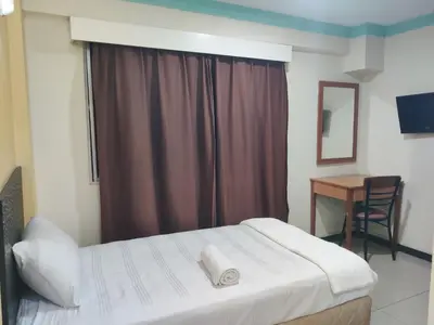 a bedroom with a bed and a desk and a window at Hotel WKL in Kuala Lumpur