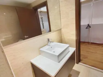 a bathroom with a white sink and a mirror at Spacious Home for 6pax - Regalia Suite - Infinity Pool with KL City View - Free Wi-Fi & Parking in Kuala Lumpur