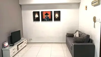 a living room with a couch and a tv at Spacious Home for 6pax - Regalia Suite - Infinity Pool with KL City View - Free Wi-Fi & Parking in Kuala Lumpur