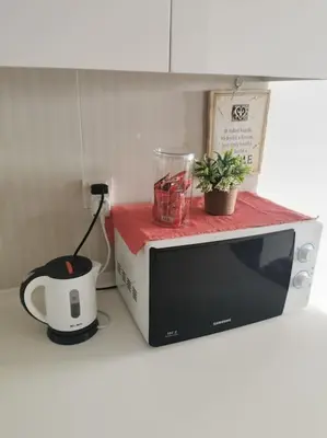 a microwave on a kitchen counter with a tea pot and a blender at Studio with an amazing view. 10 min to KLCC in Kuala Lumpur