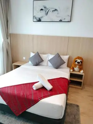 a bedroom with a large bed with a teddy bear on it at The Luxe Suites KLCC by Cozy Stay in Kuala Lumpur