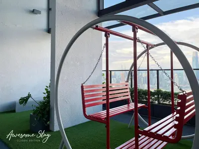 a swing on a balcony with a view of the city at Trion @ KL By Awesomestay in Kuala Lumpur