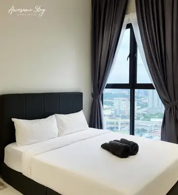 a bed with a towel on it in front of a window at Trion @ KL By Awesomestay in Kuala Lumpur