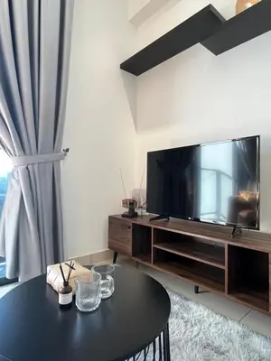 a living room with a table and a large television at Trion @ KL By Awesomestay in Kuala Lumpur