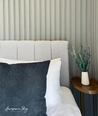 a bed with a black pillow and a vase with a plant at Neu Suites By Awesomestay in Kuala Lumpur