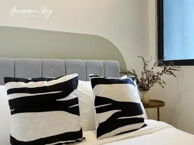a bed with two black and white pillows on it at Neu Suites By Awesomestay in Kuala Lumpur