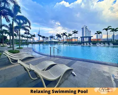 a swimming pool with two white chairs and palm trees at Trion @ Kuala Lumpur near KLCC TRX by Cityscape in Kuala Lumpur