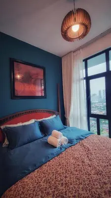 a bedroom with a bed with blue walls and a window at King Studio Suite Legasi Kampung Bharu view KLCC in Kuala Lumpur
