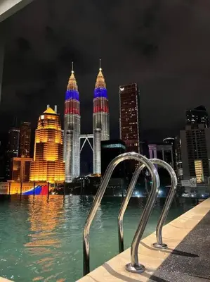 a view of a city at night from the water at King Studio Suite Legasi Kampung Bharu view KLCC in Kuala Lumpur