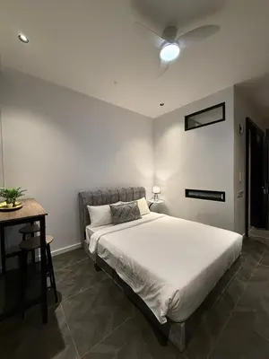 a bedroom with a large bed and a table at Scarletz Suites KLCC Kuala Lumpur by OKIDOKI Homes in Kuala Lumpur