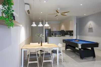 a dining room with a table and a pool table at Quill Residence Premium Cozy Suite By Ares Homestay in Kuala Lumpur