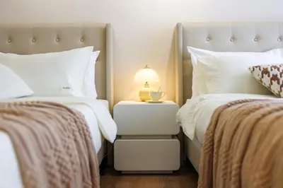 a bedroom with two beds and a lamp on a night stand at Quill Residence Premium Cozy Suite By Ares Homestay in Kuala Lumpur