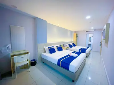 a bedroom with two beds with blue and white sheets at StarQ Hotel Bukit Bintang in Kuala Lumpur