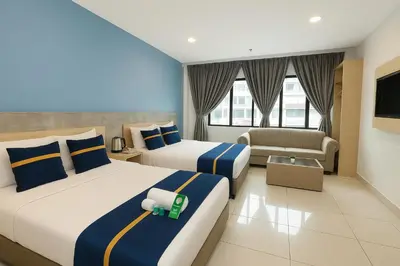 a hotel room with two beds and a couch at StarQ Hotel Bukit Bintang in Kuala Lumpur