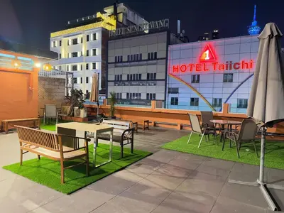 a hotel patio with tables and chairs and an umbrella at StarQ Hotel Bukit Bintang in Kuala Lumpur