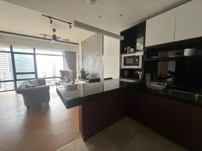 a kitchen with a counter top and a living room at Anggun KL MY in Kuala Lumpur