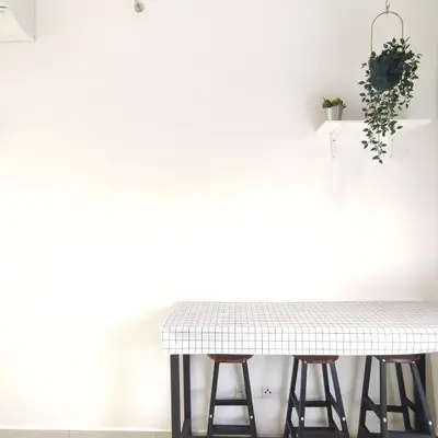 a white kitchen with a table and stools at TRION Studio 4 PAX Eleventen in Kuala Lumpur