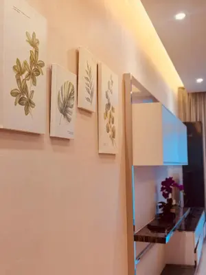 four pictures hanging on a wall next to a shelf at Dorsett Infinity Pool KL in Kuala Lumpur
