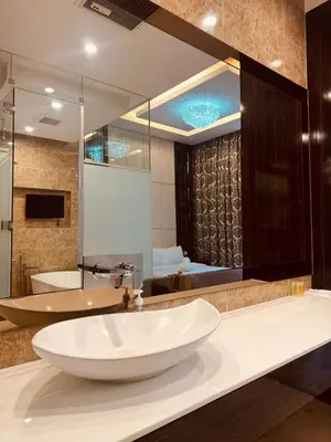 a bathroom with a large white sink and a tub at Dorsett Infinity Pool KL in Kuala Lumpur