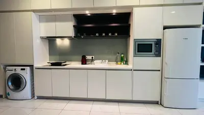a kitchen with white cabinets and a refrigerator at The Platinum KLCC By Classy in Kuala Lumpur