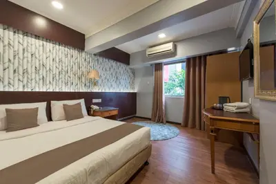 a hotel room with a bed and a desk at Grand Orchard Hotel Premier in Kuala Lumpur