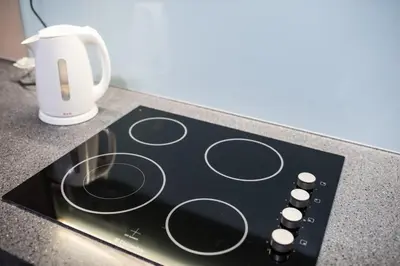 a black stove top with a coffee cup on a counter at KLCC EST Bangsar By PSM in Kuala Lumpur
