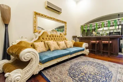 a living room with a couch and a mirror at Bangsar Villa for groups, event space and family fun in Kuala Lumpur