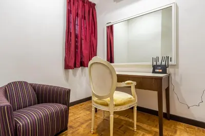 a chair sitting next to a desk with a mirror at Bangsar Villa for groups, event space and family fun in Kuala Lumpur