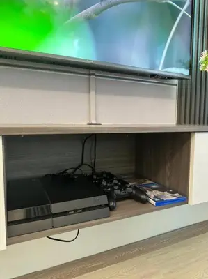 a tv sitting on a shelf with a video game controller at Sunset View at Modern Home in Kuala Lumpur