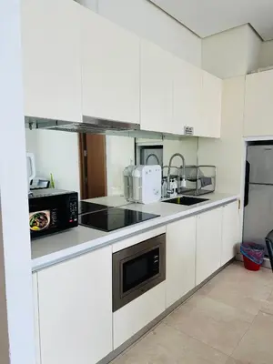 a white kitchen with a sink and a microwave at vortex klcc apartment by Dream NIGHT in Kuala Lumpur