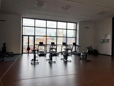 a gym with cardio equipment in front of a large window at KL Chambers Suites BY Fortune in Kuala Lumpur