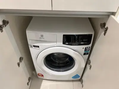 a washer and dryer in a kitchen under a counter at KL Chambers Suites BY Fortune in Kuala Lumpur