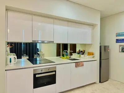 a kitchen with white cabinets and a refrigerator at Sky Suites KL City Center in Kuala Lumpur