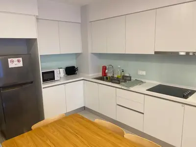 a kitchen with white cabinets and a stainless steel refrigerator at SS KL Sentral by NomadNest in Kuala Lumpur