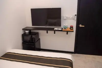 a room with a bed and a tv on a wall at Neu Suites Studio Room - 3km to KLCC, 8 mins walk to LRT in Kuala Lumpur