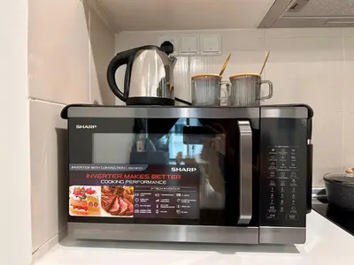 a microwave oven with a tea kettle on top of it at Razak City Residences, Sungai Besi by Rverse Suite in Kuala Lumpur