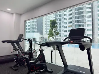 two exercise bikes in a room with a large window at Razak City Residences, Sungai Besi by Rverse Suite in Kuala Lumpur