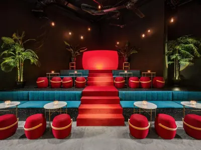 a stage with red and blue chairs and red stairs at 163 SUPER KING BED STUDIO near Petronas Twin Tower KLCC KL Convention Center by Zen Glo in Kuala Lumpur