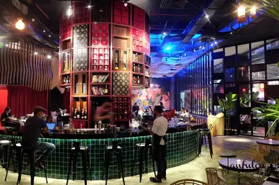 a bar in a restaurant with people standing around it at 163 SUPER KING BED STUDIO near Petronas Twin Tower KLCC KL Convention Center by Zen Glo in Kuala Lumpur
