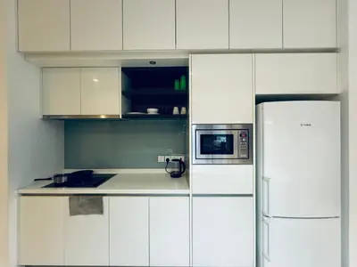 a white kitchen with a refrigerator and a microwave at The Platinum KLCC by Skyline in Kuala Lumpur
