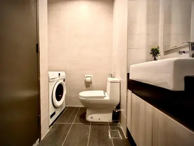 a bathroom with a toilet and a sink and a washing machine at Premium Cozy Studio Near Mid Valley in Kuala Lumpur