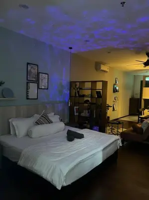 a bedroom with a large bed with a blue ceiling at Premium Cozy Studio Near Mid Valley in Kuala Lumpur