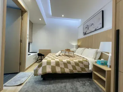 a bedroom with a bed with a table on it at The Luxe & The Colony Infinitum by Romeo Bnb in Kuala Lumpur