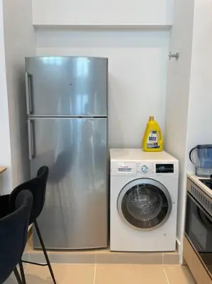 a kitchen with a refrigerator and a washing machine at The Luxe & The Colony Infinitum by Romeo Bnb in Kuala Lumpur