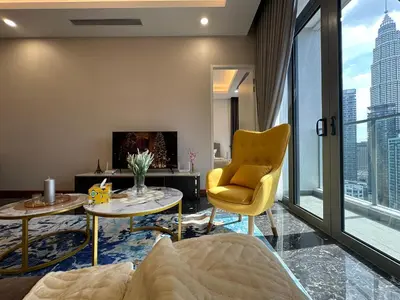 a living room with a yellow chair and a tv at Royce Residences by Romeo Bnb in Kuala Lumpur