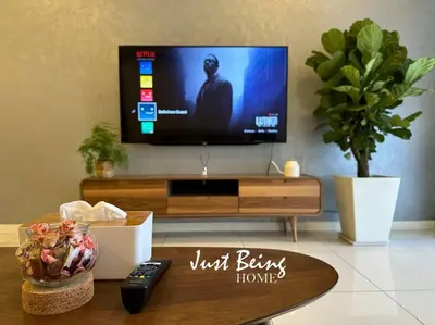 a living room with a television and a coffee table at Just Being Home 5pax 1BR/1BA 1Queen/1Single/1Sofa in Kuala Lumpur