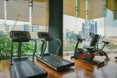 a gym with three cardio machines in front of a window at Casa Residency Service Apartment By Moonlight in Kuala Lumpur