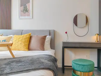 a bedroom with a bed and a stool and a mirror at Scarletz Suites KLCC by KAN's in Kuala Lumpur