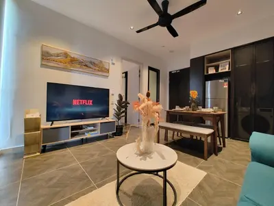 a living room with a tv and a vase of flowers at Scarletz Suites KLCC by KAN's in Kuala Lumpur